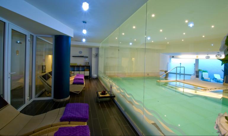 Indoor pool with loungers and relaxing atmosphere.